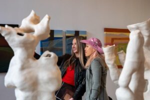 Visitantes observando esculturas orgánicas blancas en la exposición colectiva de Lisboa.