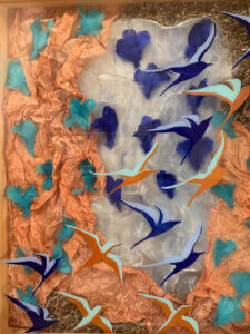 Obra mixta "Las aves deben vivir libres" de Graciela Musteikis - aves pintadas en acrílico sobre placa transparente con plumas y malla de cobre al fondo, 160x98cm